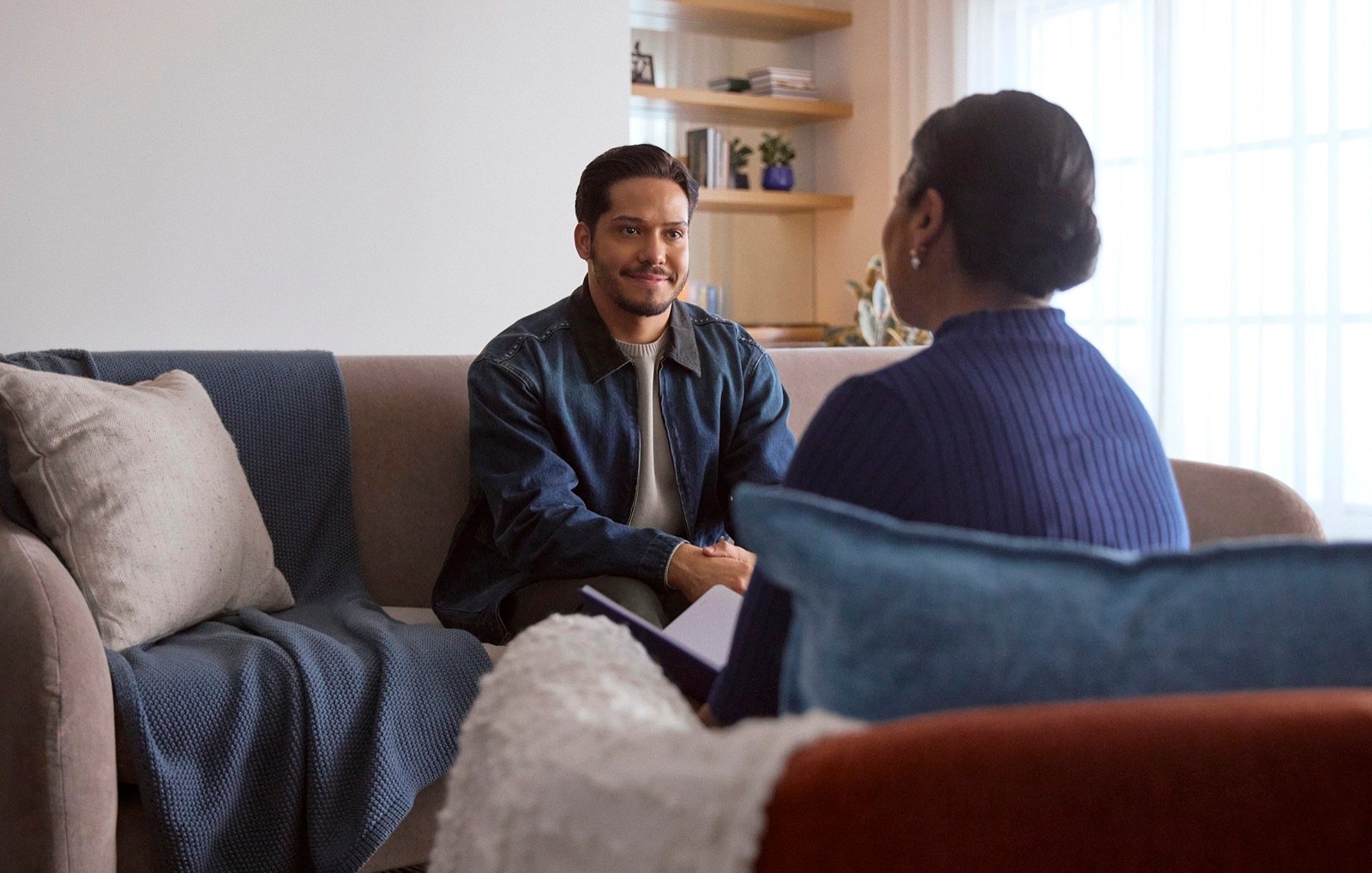 Bruno DiSanto in a television commercial scene, in conversation on a couch